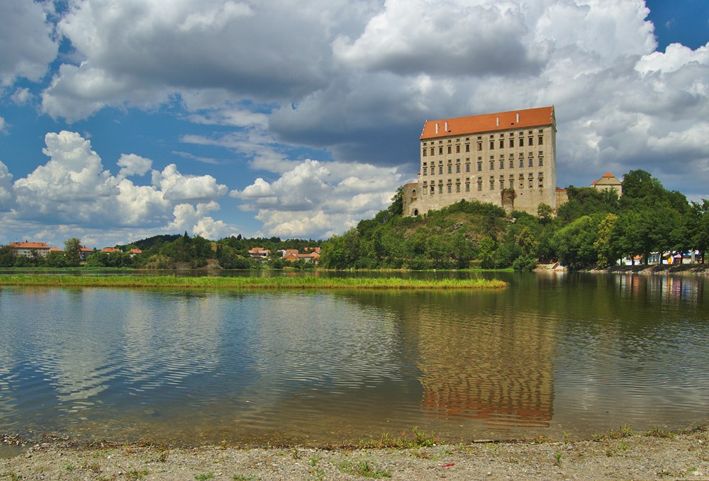 Zámek Plumlov tyčící se nad přehradou. 